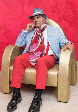 A photograph of an older man sitting in a stylish chair