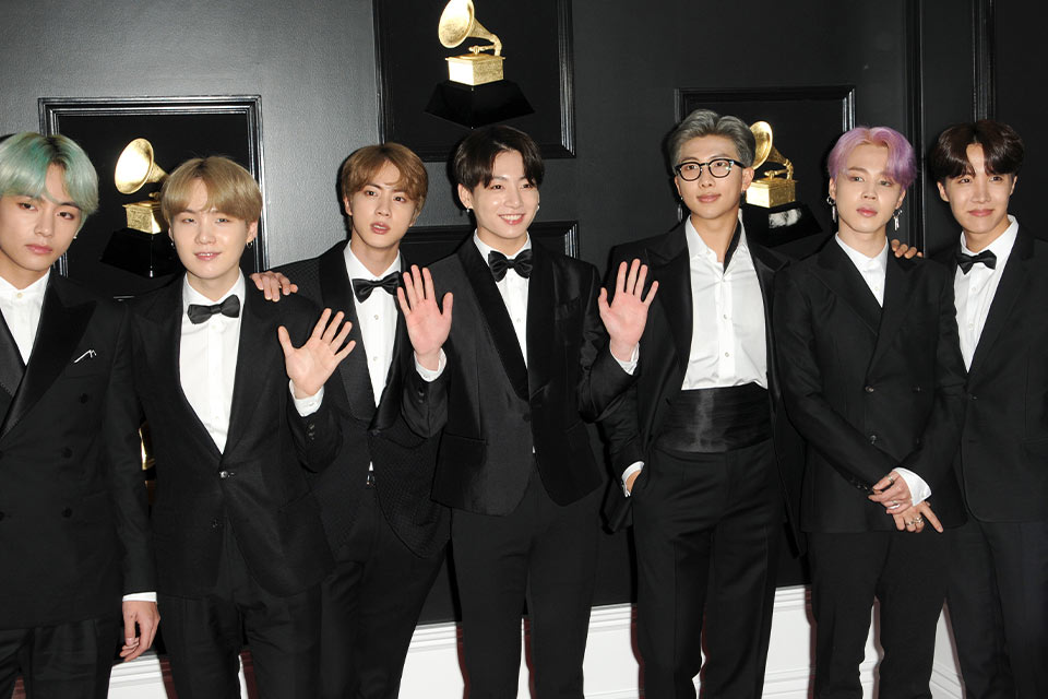 A photograph of a group of young Korean men in tuxedos.