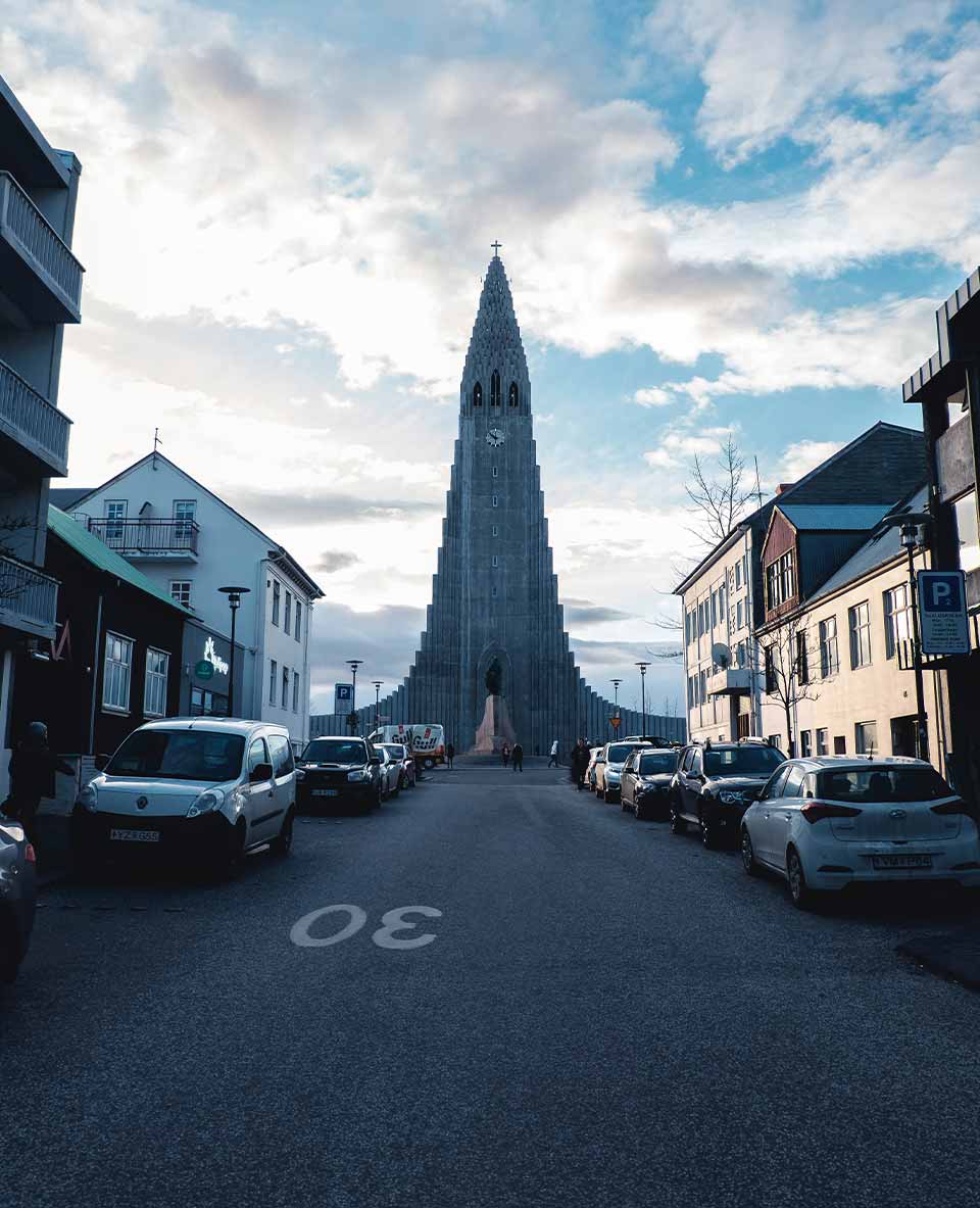 A photograph of a building that sits at the end of a busy road