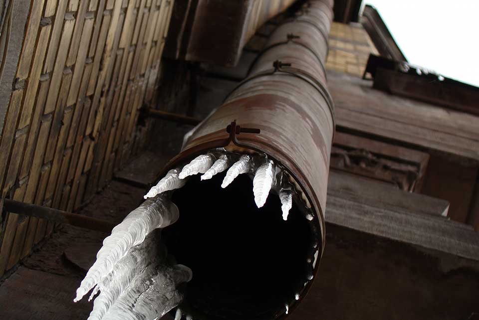 A photograph of a pipe with ice emerging from it, shot from below