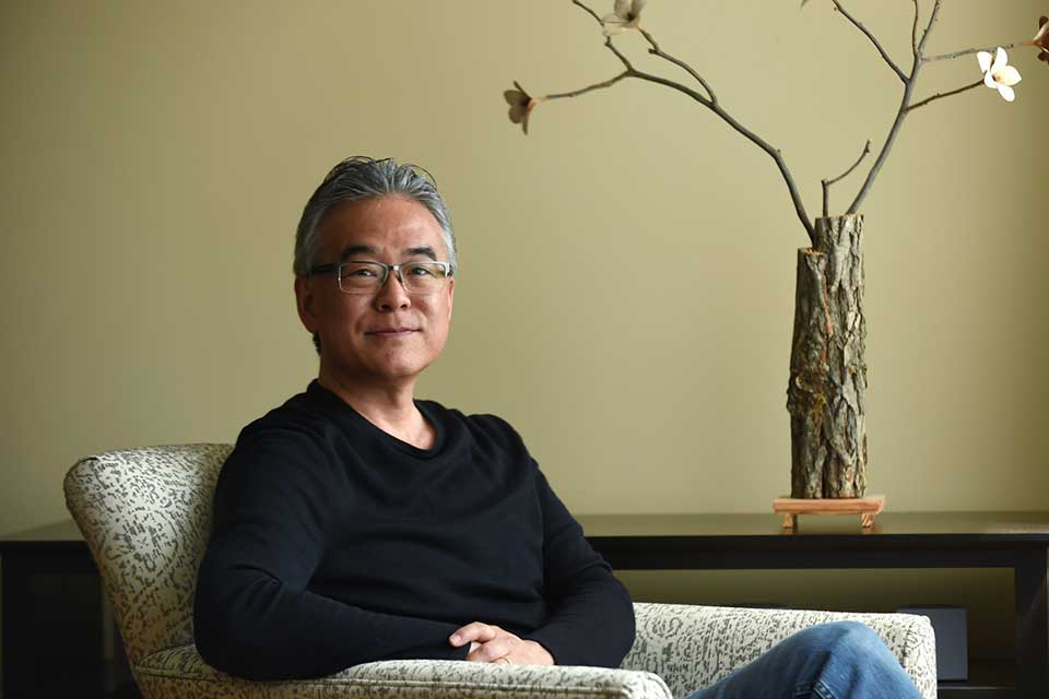 A photograph of Aaron Caycedo-Kimura seated in a chair