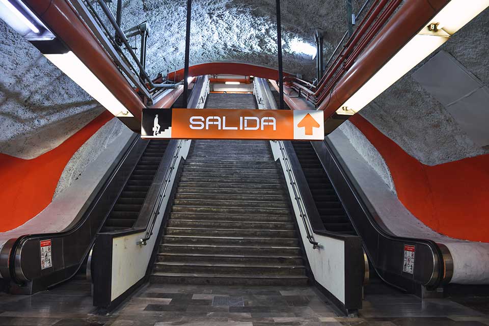 An escalator rising up out of the frame. A sign above reads: Salida.