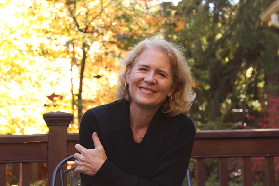 A photograph of author Suzanne Berne, who smiles at the viewer