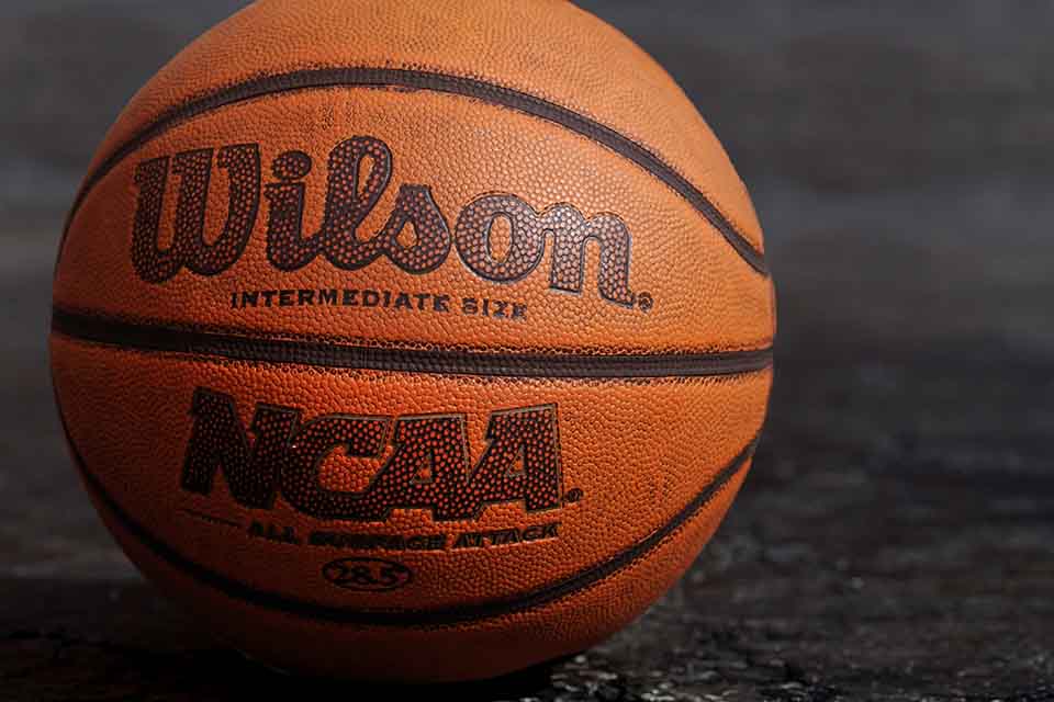 A close up photograph of a basketball. Text on the ball reads: Wilson. NCAA.