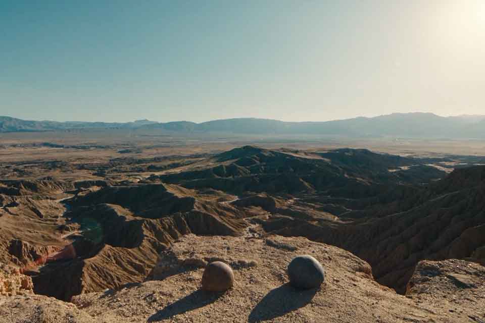 A still photograph of two rocks sitting on a cliff