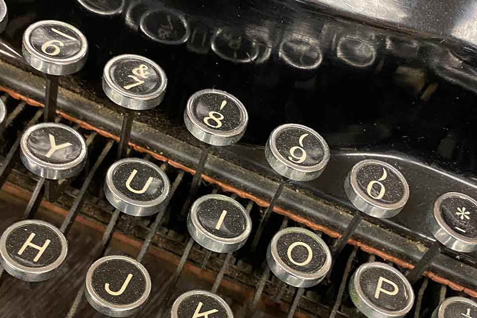 A close-up photograph of the punctuation/number row of a manual typewriter