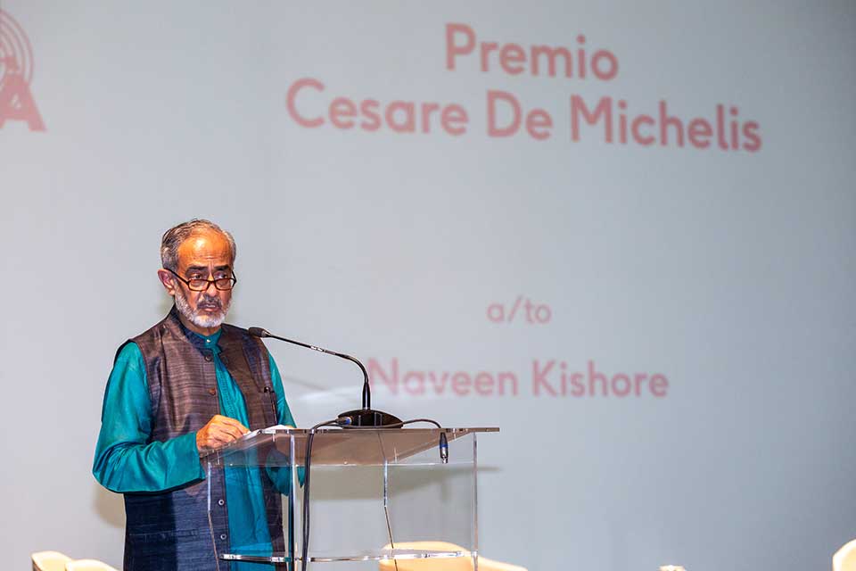 A photograph with a man standing at a lectern