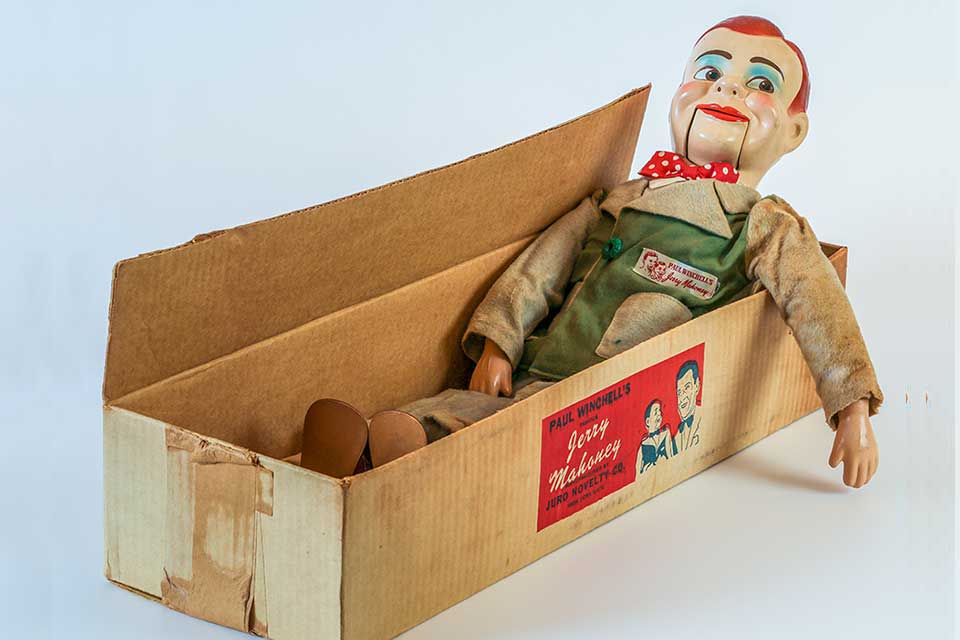 A ventriloquist's dummy in a cardboard box