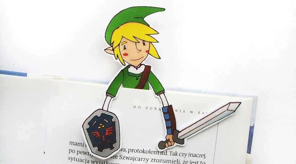 A paper cutout of Link from the Legend of Zelda peeking up from the top of a book