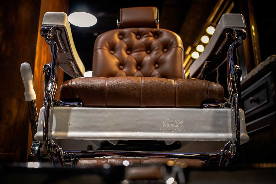 A photograph of a barber's chair as seen from the ground in front of it