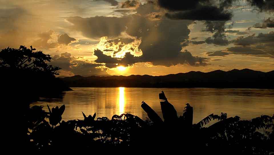 The sun sets on the opposite of the Mekong River