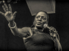 A photograph of Sharon Jones singing