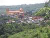 A photograph of a town nestled among the trees on a hill side