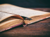 A photograph of an old book on a wooden desk