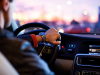 A photograph of a man driving a car shot from over his shoulder