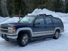 A photograph of a Chevy Suburban covered in snow