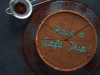 A chocolate pie with the words Have a Safe Trip written on it in frosting