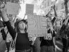 A black and white photograph of young people, many wearing masks, protesting climate inaction