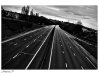 A black and white photograph of an deserted urban highway