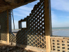 A photograph from inside a crumbling building that looks out toward the sea