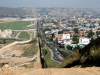 A photo of the border between the United States and Mexico showing sparse population on the US side and signs of high density populations on the Mexican side