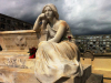 A statue of a reclining figure in a cemetery