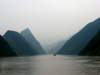 A photograph of a foggy river with a boat visible in the distance