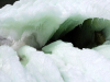 Thick sheets of ice warp to reveal a dark hole within