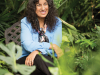 Margarita Engle sits smiling surrounded by plants