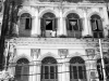 A black and white photograph of the front of a tenement building