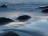 A photograph of rocks, mostly submerged in the tide