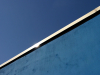 A photograph of the top of a border wall and the blue sky above