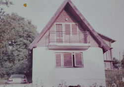 A faded color photograph of an old farm house