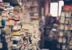 Stacks of books in a room with a window