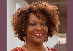 A photograph of Rita Dove, who is smiling while looking at the photographer