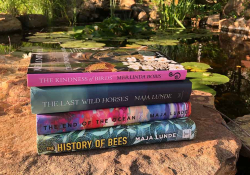 A photograph of the book discussed in the article below in a stack on a rock before a small pond