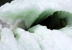 Thick sheets of ice warp to reveal a dark hole within