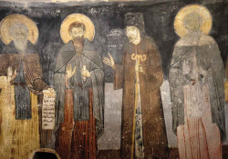 A photograph of a weathered religious painting with four male figures