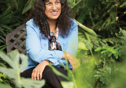 Margarita Engle sits smiling surrounded by plants