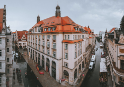 A panaroma shot of Leipzig with a large building protruding in the foreground