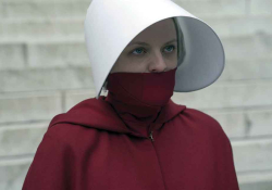 A photograph of a woman in a red cloak and a white hat