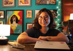 A photograph of bookstore owner Lucy Yu sitting at a desk with book open in front of her