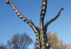 A photograph of an usual hat stand, the hanging pegs resembling octopus arms